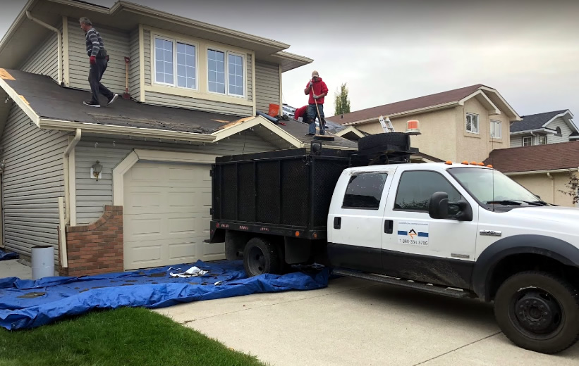 Photo of the dump truck we throw old shingles and roofing debris and trash into parked in front of a Calgary home