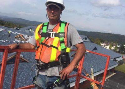 Photo of one of our roofers in the basket of a cherry-picker truck