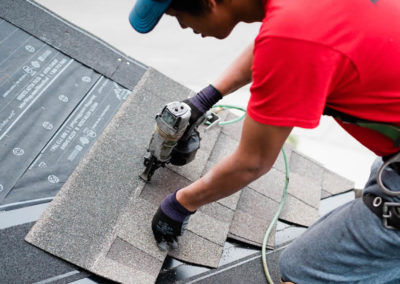 Photo of our roofer nailing asphalt shingles to a Calgary roof