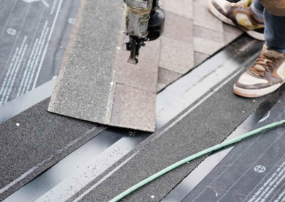 Photo of our roofer nailing new asphalt shingles to a Calgary residential roof