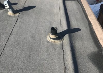 Photo of a flat roof with a protruding ventilation pipe