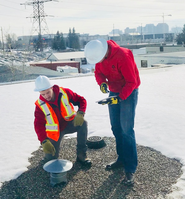 Photo of our flat roofing specialty roofer inspection air vents on a commercial flat roof project in Calgary