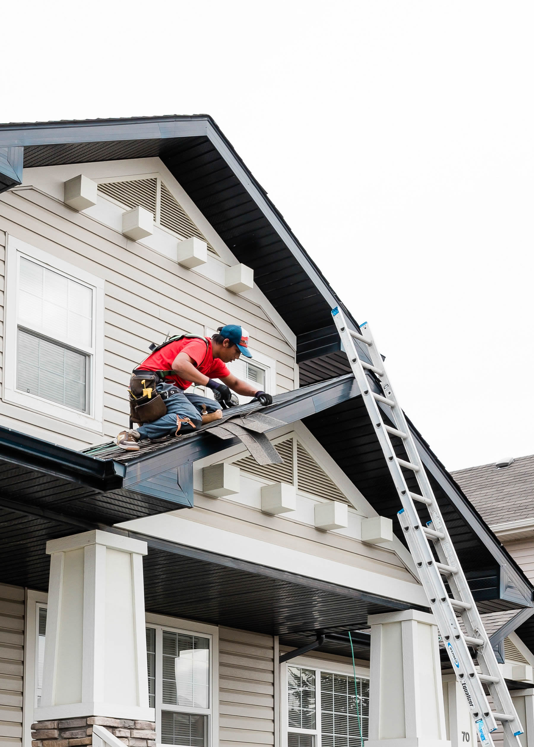 Photo of our roofers installing new asphalt shingles to a Calgary residence