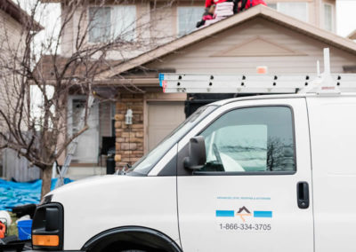 Photo of our roofers unpacking asphalt shingle packages for a new Calgary residential roof