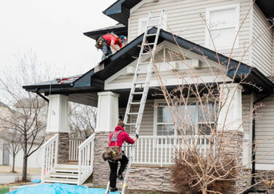 Photo of our roofers installing a new residential roof in a Calgary suburb