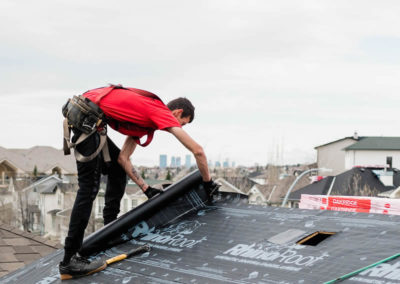Photo of one of our roofers installing RhinoRoot underlay to a Calgary residential roof