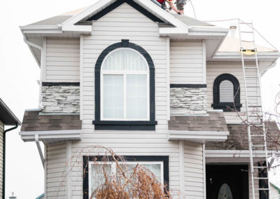 Photo of our roofers installing woven synthetic underlay for a suburban Calgary home's roof repair