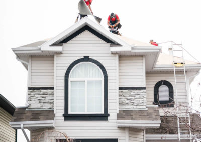Photo of our roofers installing new synthetic roofing underlay to a Calgary suburban home
