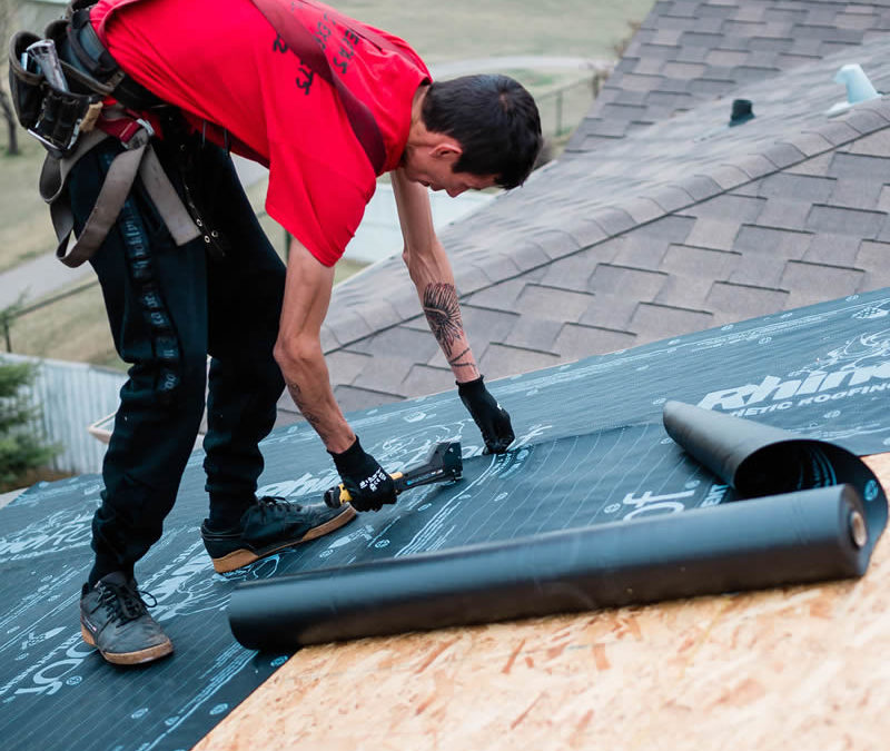 Photo of our roofer installing roofing underlay to a Calgary home