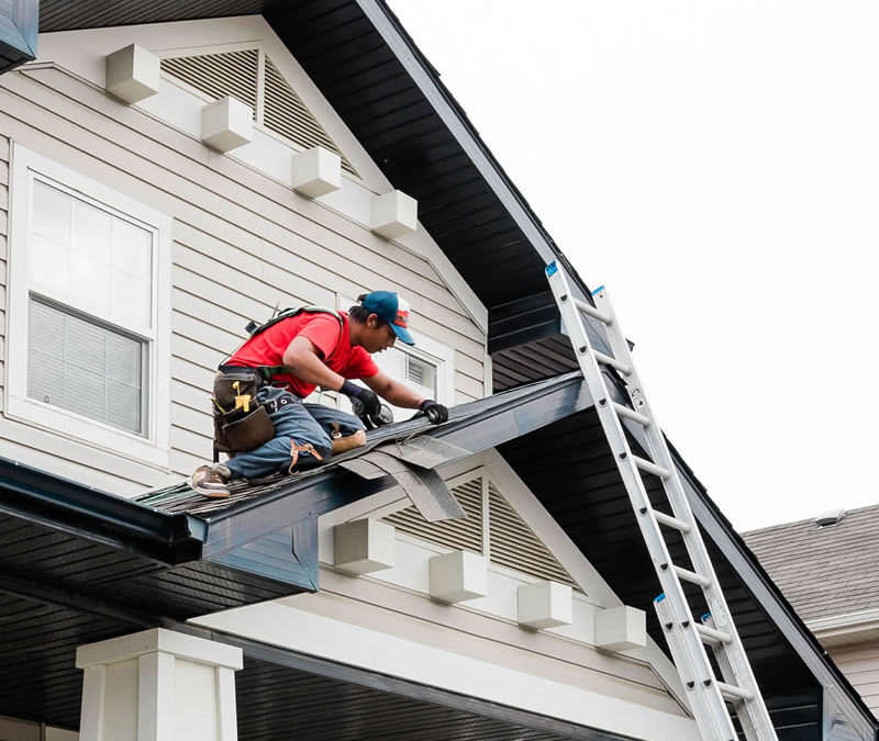 Photo of our roofer installing asphalt shingles to an entryway roof