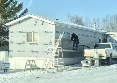 Photo of our siding installer putting new siding on a Calgary mobile home