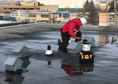 Photo of our flat roofer fixing a commercial flat roof with tar