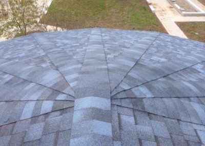 Photo of new asphalt shingles on a large, round Calgary commercial roof