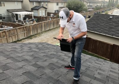 Photo of our roofer inspecting a Calgary residential roof