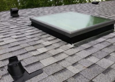 Photo of a roof that has asphalt shingles installed around a skylight